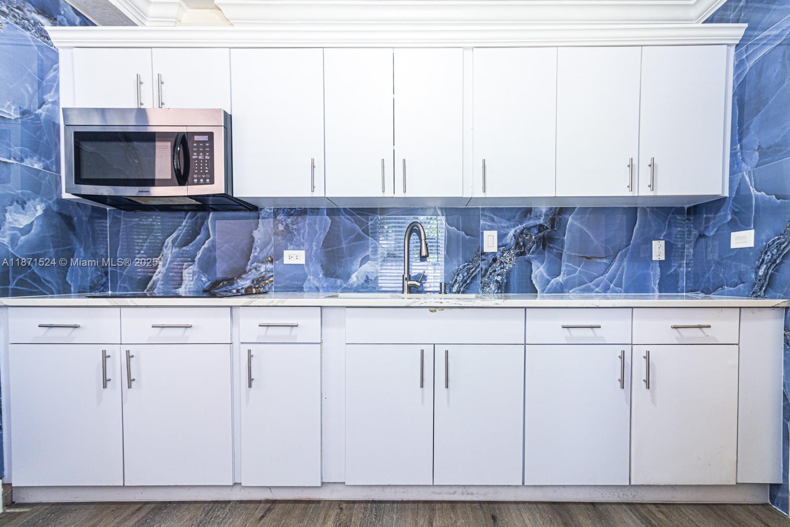 15600 Northwest 157th St Road Miami Gardens, FL 33054 - Photo 3 of 25 a kitchen with stainless steel appliances white cabinets and a microwave oven