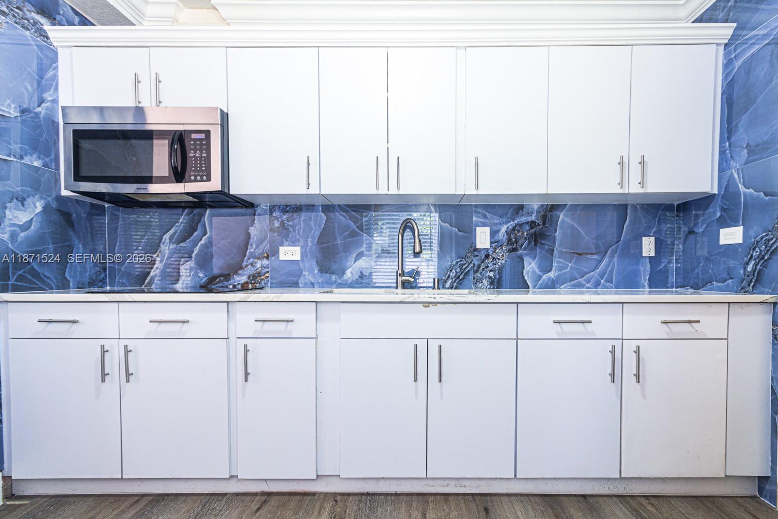 15600 Northwest 157th St Road Miami Gardens, FL 33054 - Photo 3 of 21 a kitchen with stainless steel appliances white cabinets and a microwave oven