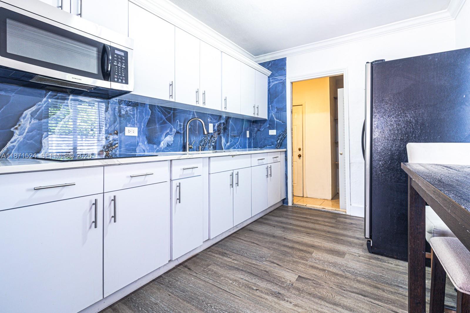 15600 Northwest 157th St Road Miami Gardens, FL 33054 - Photo 4 of 21 a kitchen with granite countertop white cabinets and wooden floor