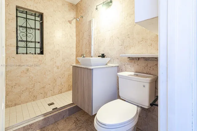 a white toilet sitting next to a bathroom sink