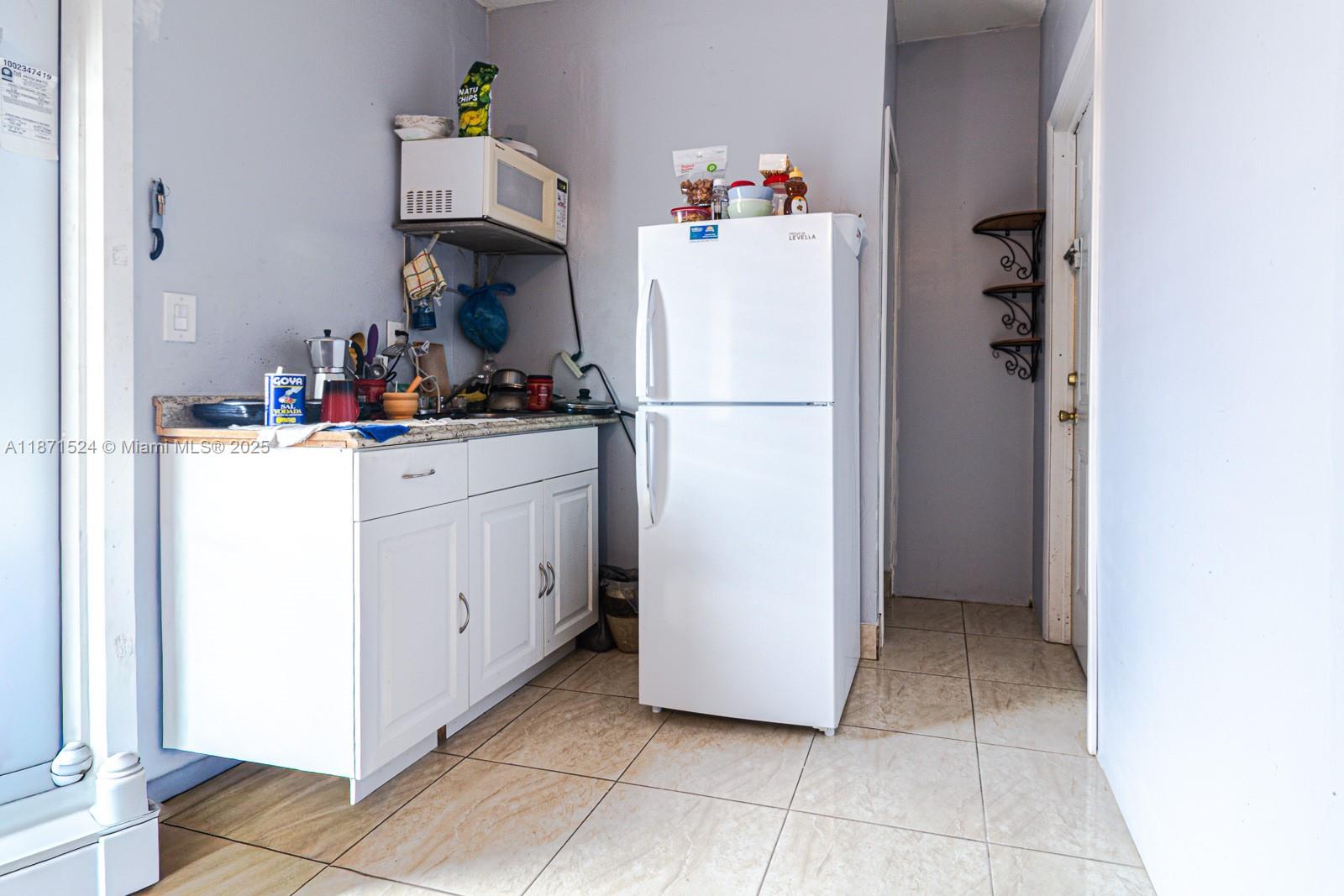15600 Northwest 157th St Road Miami Gardens, FL 33054 - Photo 8 of 25 a kitchen with a refrigerator and cabinets