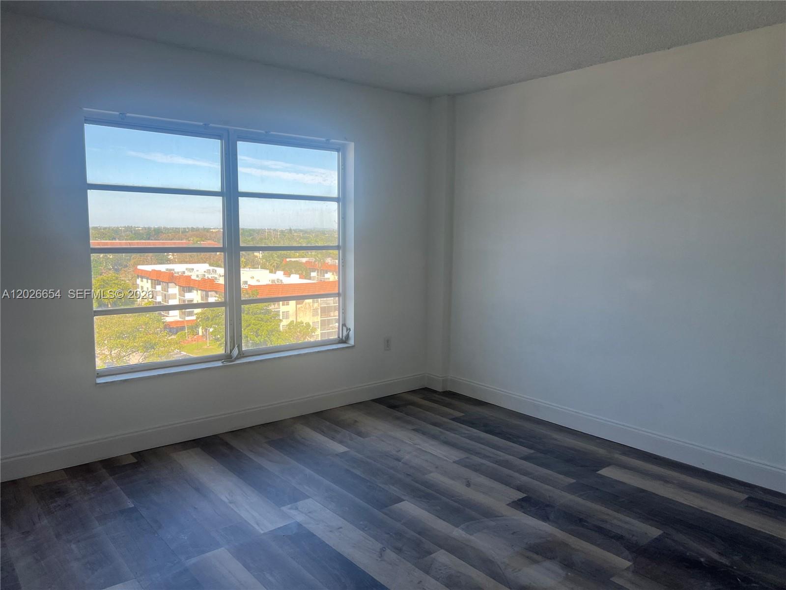 4174 Inverrary Drive, Unit 903 Lauderhill, FL 33319 - Photo 19 of 36 a view of an empty room with wooden floor and a window