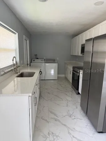 a kitchen with a sink refrigerator and cabinets