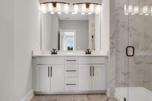 a bathroom with a sink vanity and shower