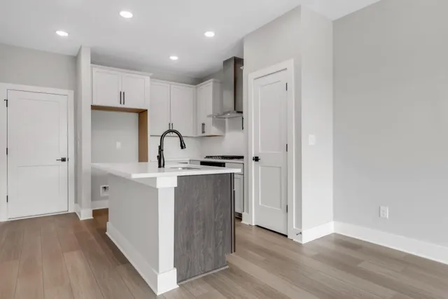 a kitchen with kitchen island a sink appliances and cabinets