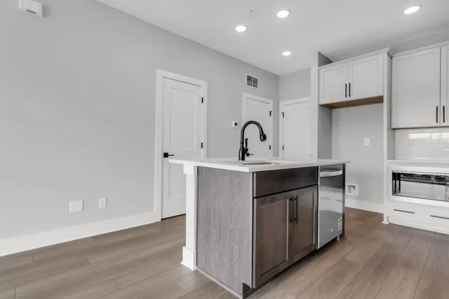 a kitchen with a sink cabinets and wooden floor