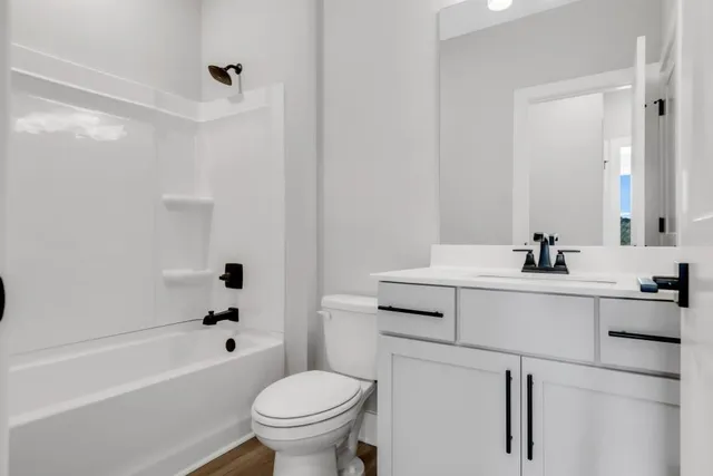 a bathroom with a sink toilet vanity and tub