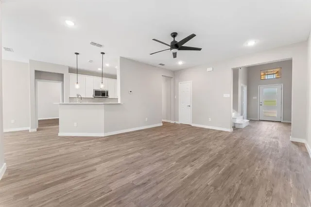 a view of a kitchen with a microwave and wooden floor