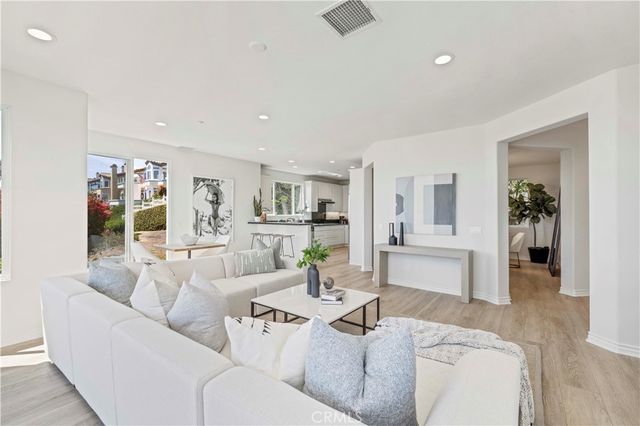 a kitchen with stainless steel appliances kitchen island a table chairs in it and white cabinets