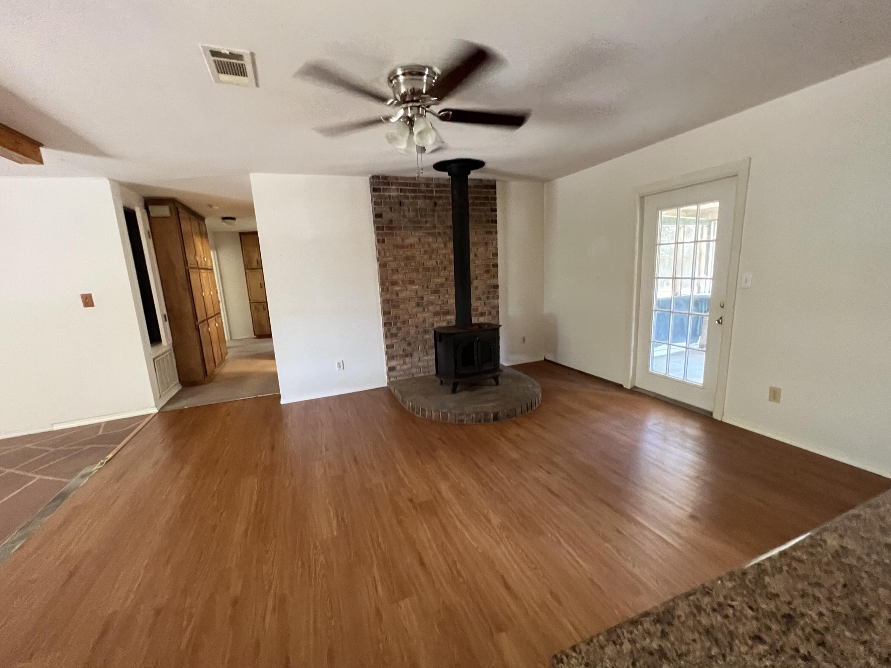 5256 Lassiter Road Milton, FL 32571 - Photo 4 of 20 a view of an empty room with wooden floor and a ceiling fan
