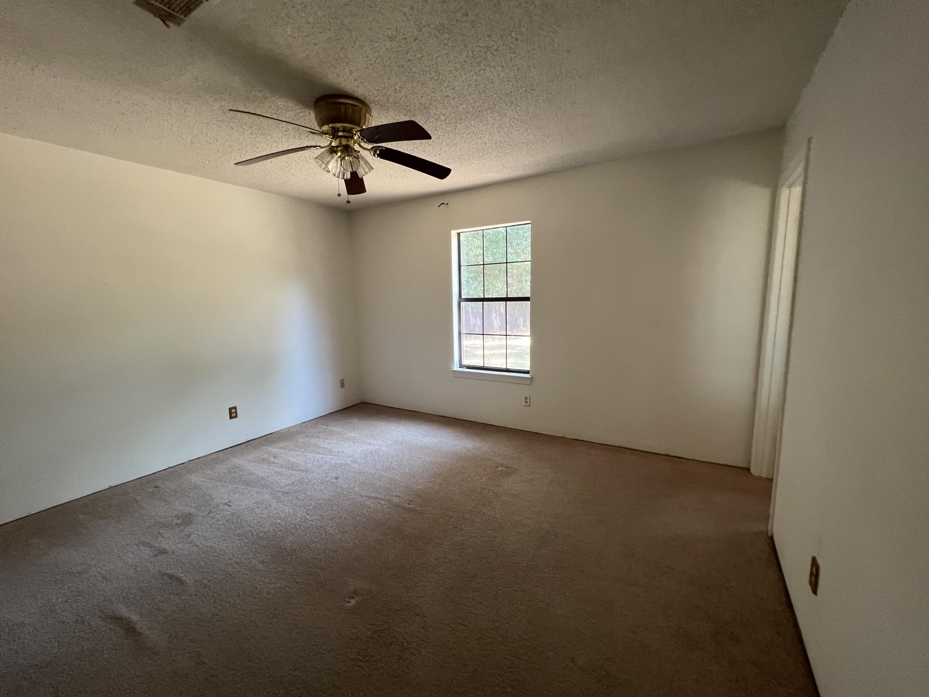 5256 Lassiter Road Milton, FL 32571 - Photo 10 of 20 an empty room with a window and a fan