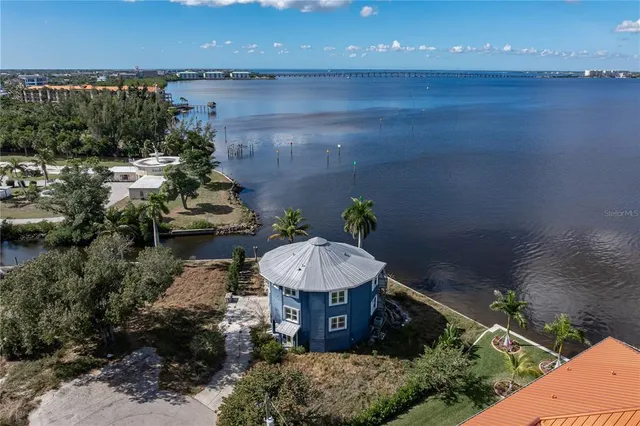 an aerial view of a house with a yard and lake view