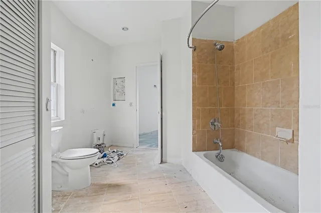 a bathroom with a granite countertop toilet a sink and bathtub