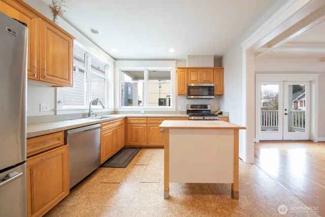 a kitchen with stainless steel appliances kitchen island granite countertop a sink and cabinets