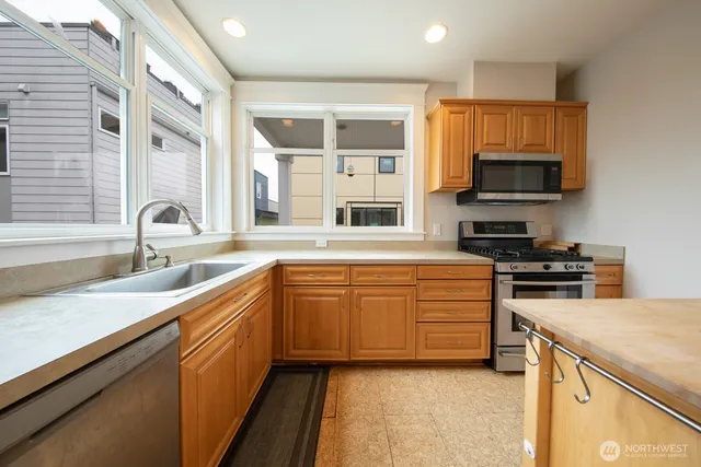 a kitchen with stainless steel appliances a stove sink microwave and cabinets