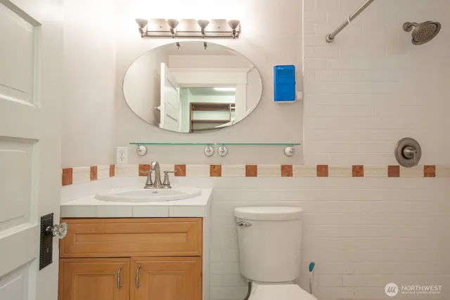 a bathroom with a sink a toilet and a mirror