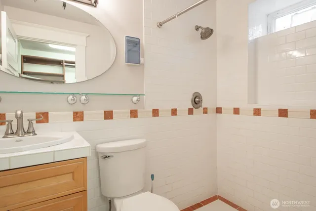 a bathroom with a sink vanity mirror and toilet