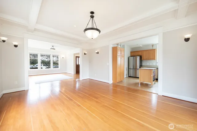 a view of an empty room with window and wooden floor