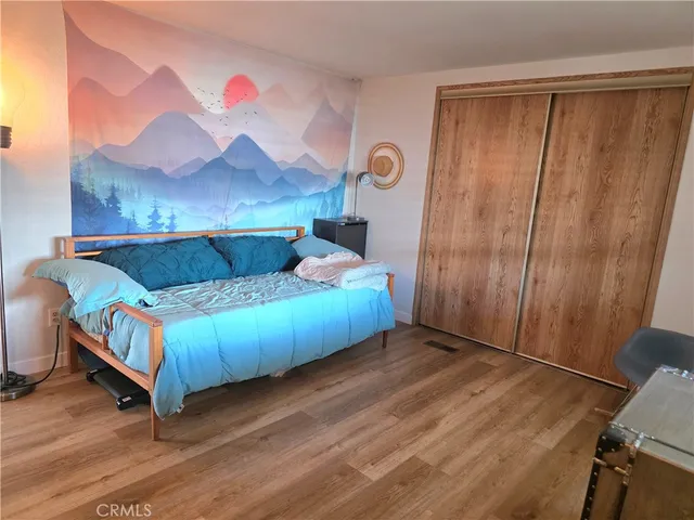 a view of a hallway with wooden floor and a living room