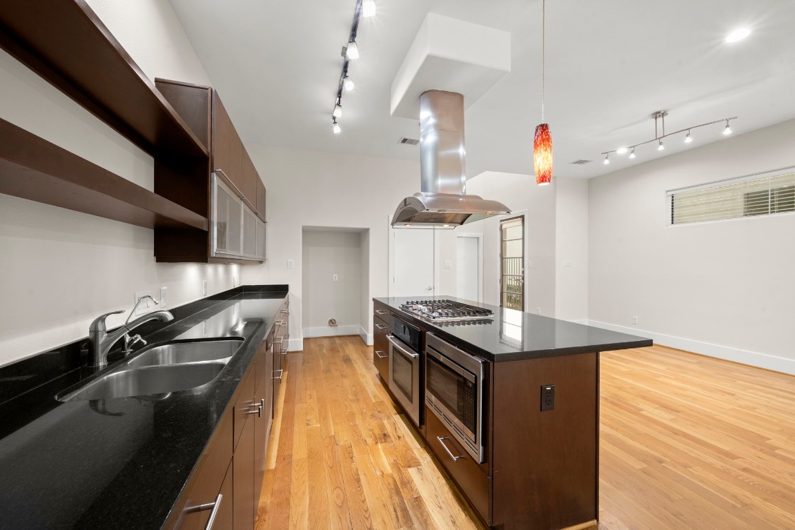 5527 Darling Street, Unit A Houston, TX 77007 - Photo 11 of 31 a kitchen with stainless steel appliances granite countertop a sink a stove and a wooden floors