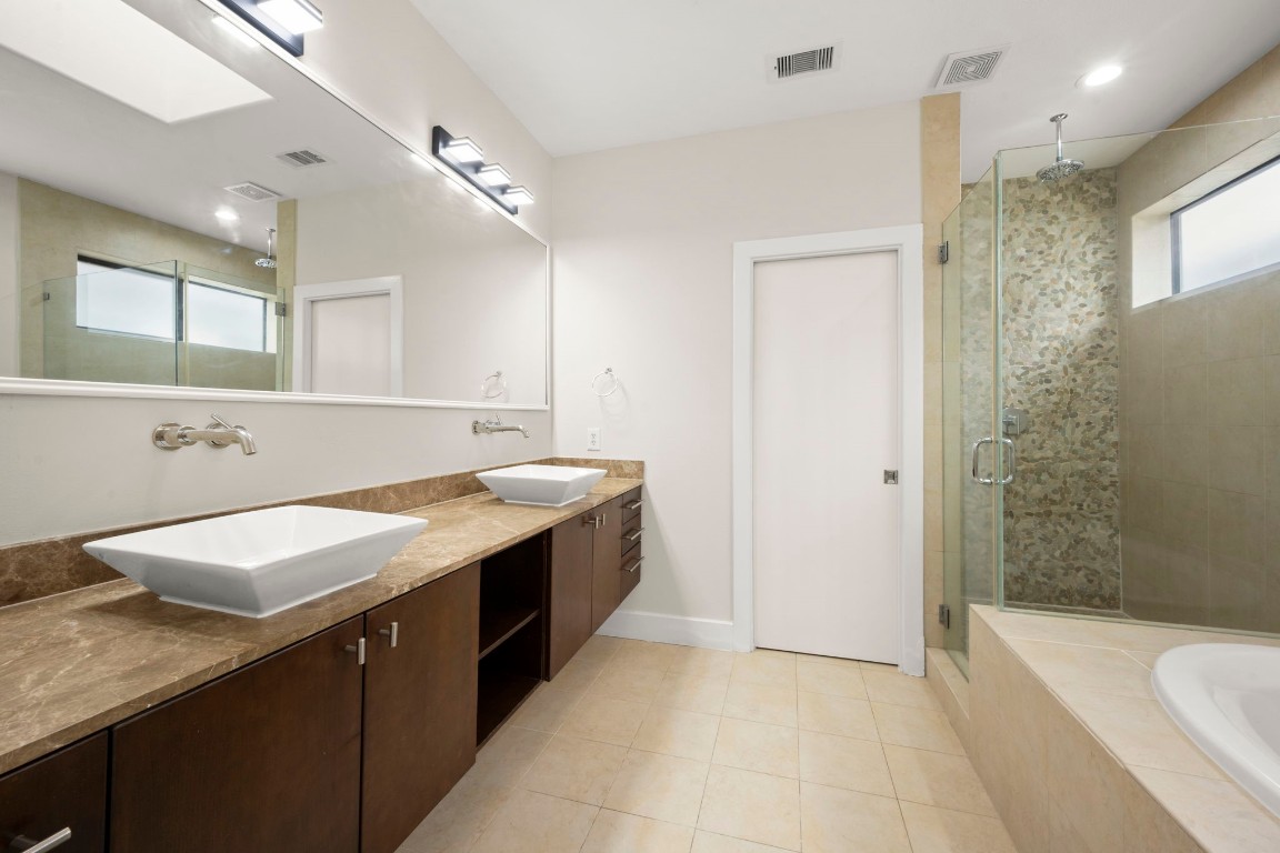 5527 Darling Street, Unit A Houston, TX 77007 - Photo 25 of 31 a bathroom with a granite countertop sink a toilet a mirror and bathtub