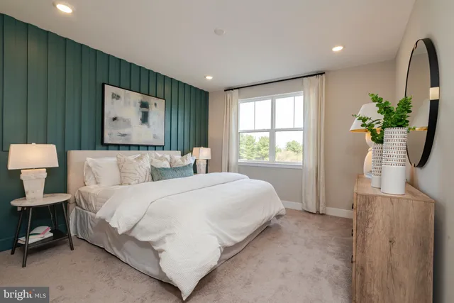 a bedroom with a bed and a dresser with mirror