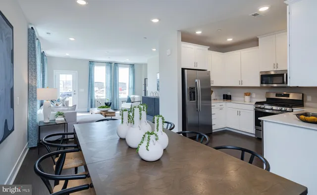 a very nice looking dining room with furniture and a refrigerator
