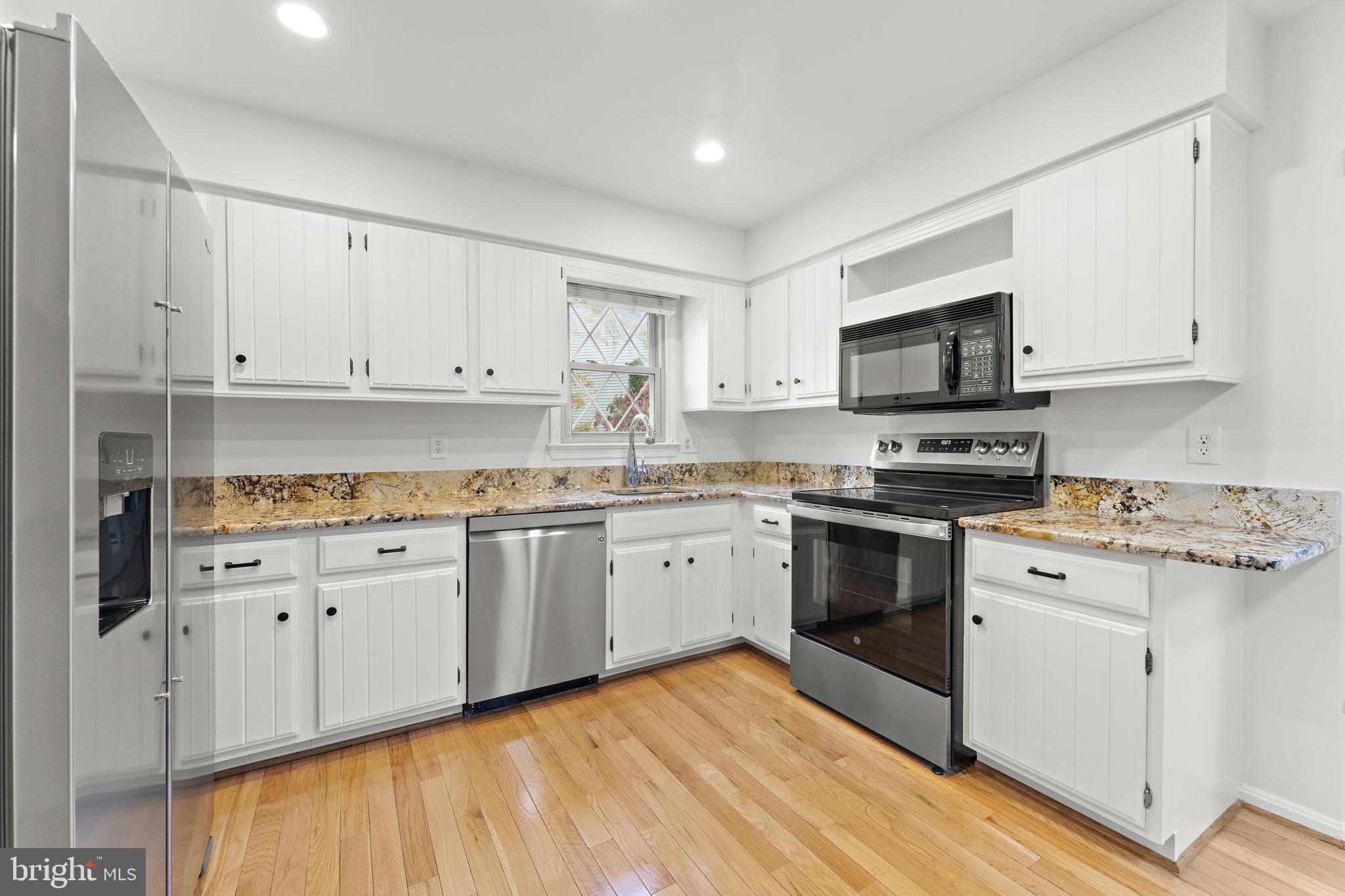 12574 Quincy Adams Court Herndon, VA 20171 - Photo 16 of 67 a kitchen with granite countertop white cabinets and stainless steel appliances