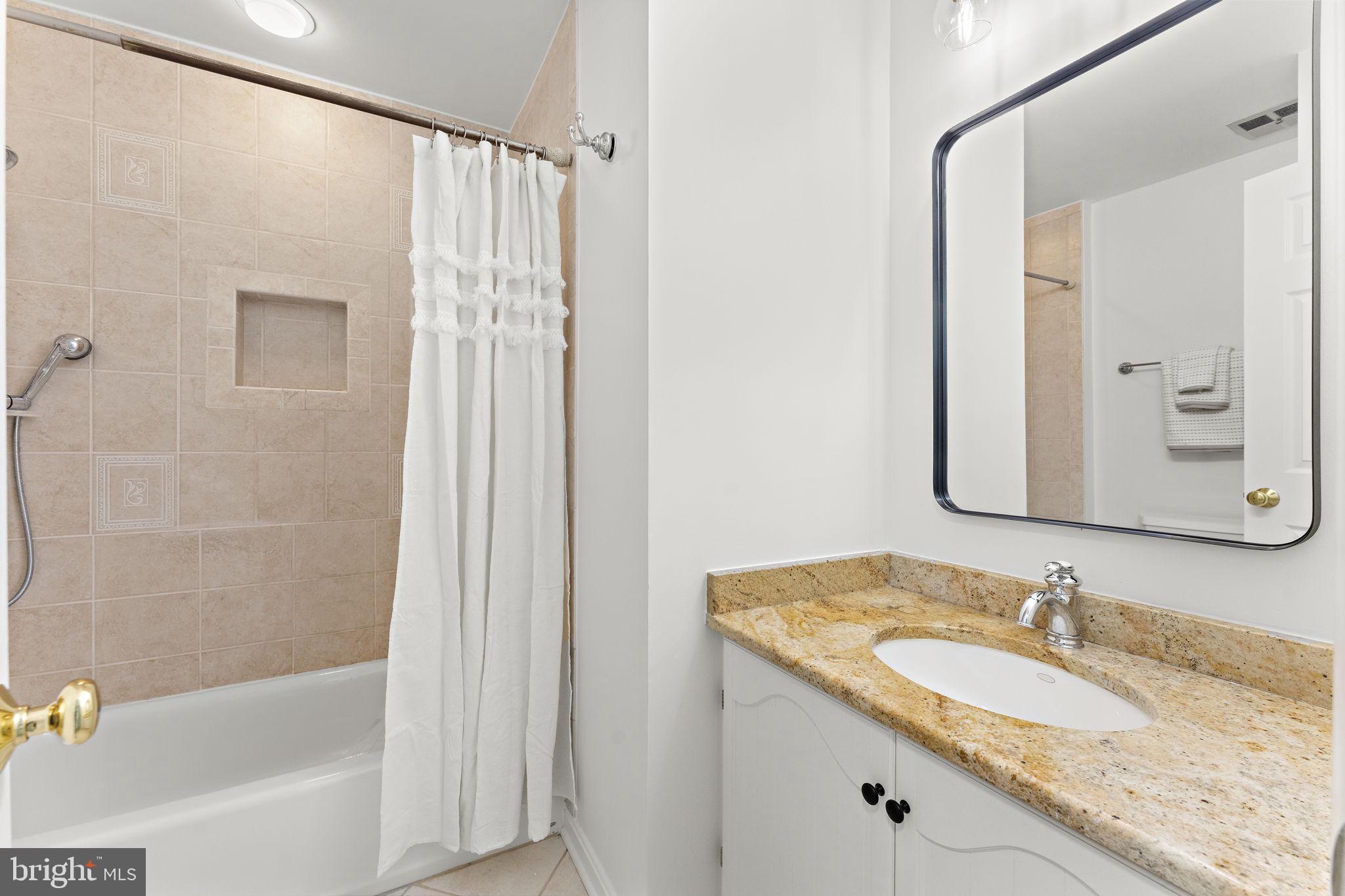 12574 Quincy Adams Court Herndon, VA 20171 - Photo 38 of 67 a bathroom with a granite countertop sink shower and a mirror