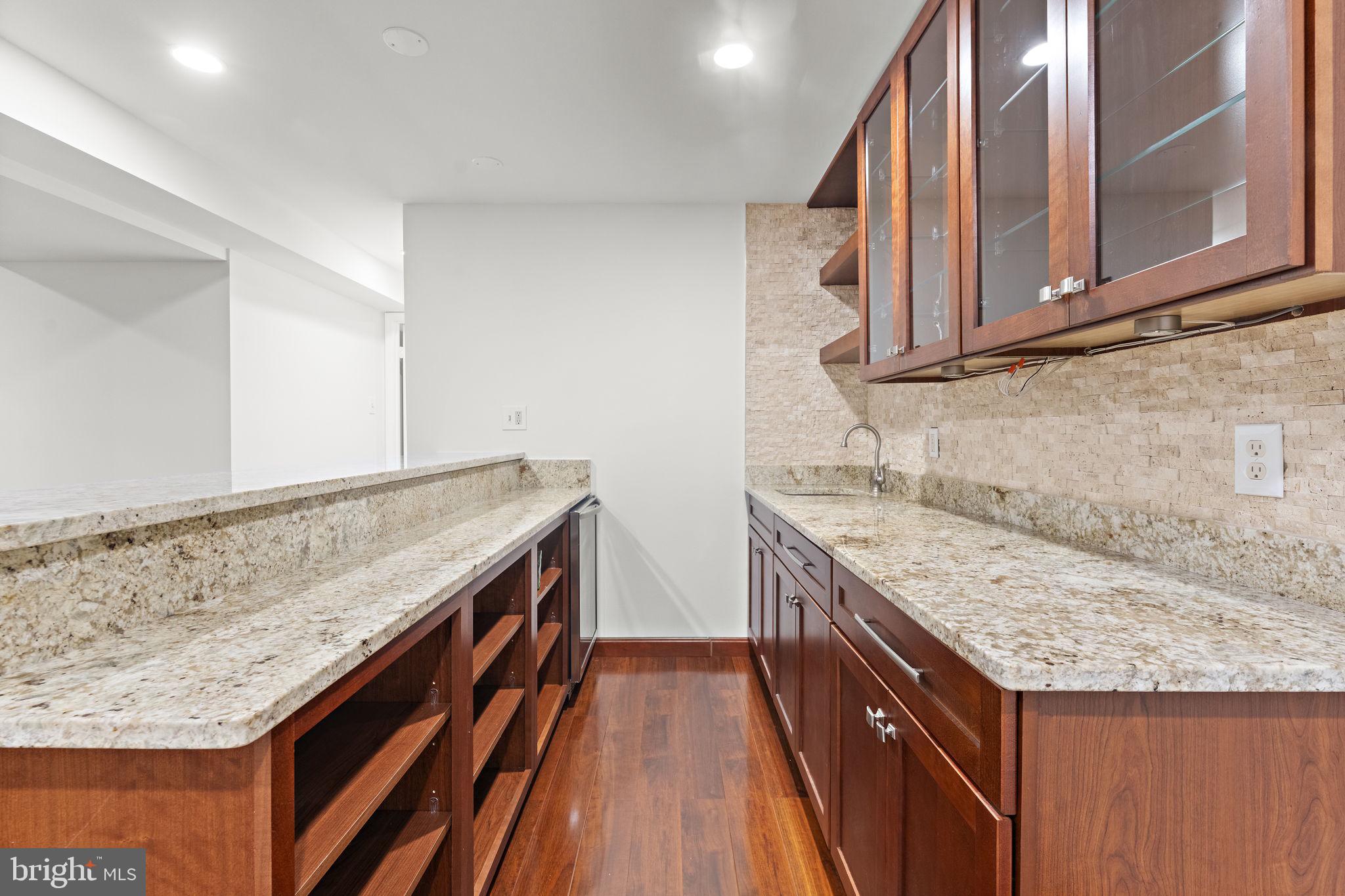 12574 Quincy Adams Court Herndon, VA 20171 - Photo 43 of 67 a kitchen with granite countertop kitchen island wooden cabinets and entryway