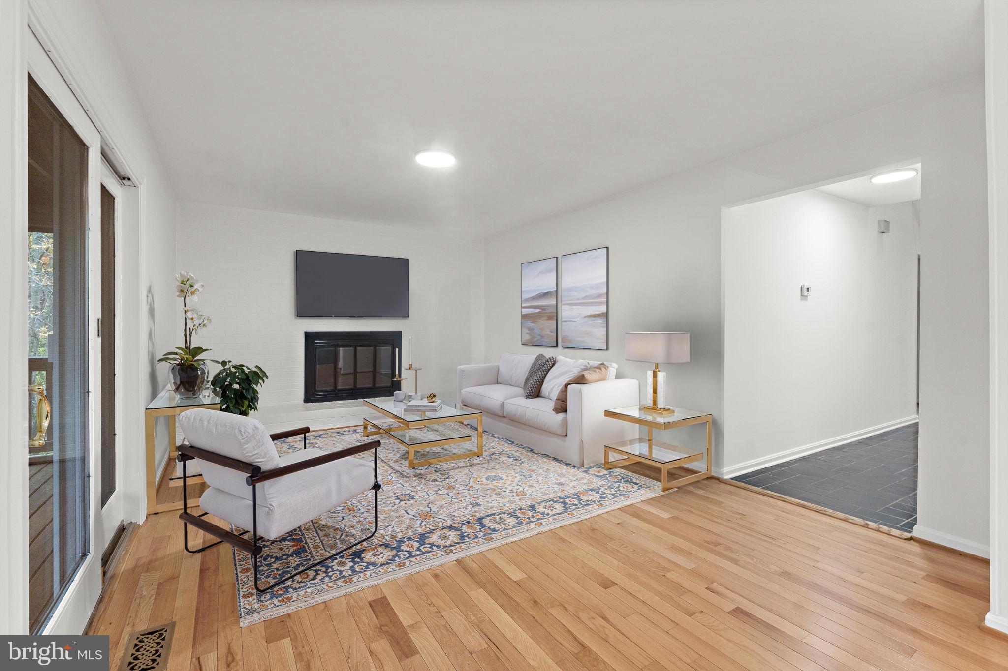 12574 Quincy Adams Court Herndon, VA 20171 - Photo 10 of 67 a living room with furniture a fireplace and a table