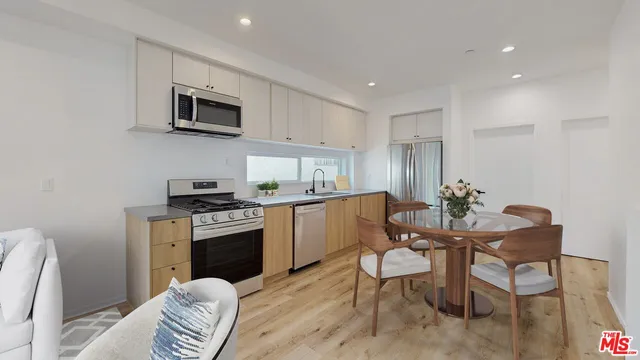 a kitchen with a table chairs microwave and cabinets