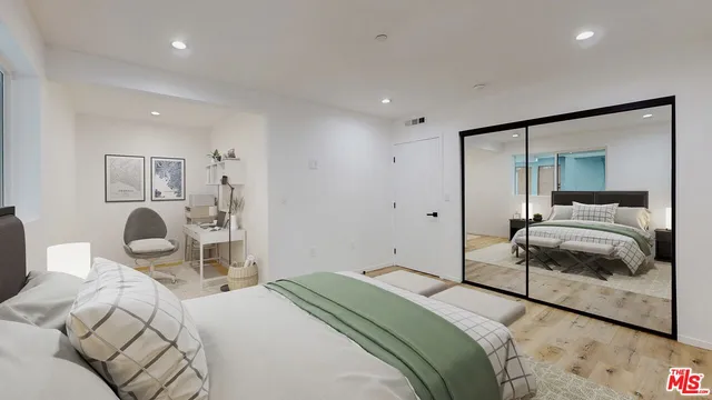 a bedroom with a bed and wooden floor