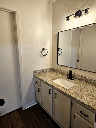 a bathroom with a granite countertop sink and a mirror
