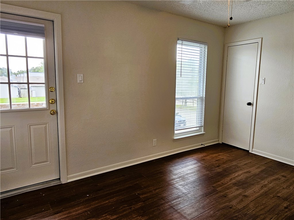 4816 Delwood Street, Unit 4 Corpus Christi, TX 78413 - Photo 19 of 22 an empty room with wooden floor and windows