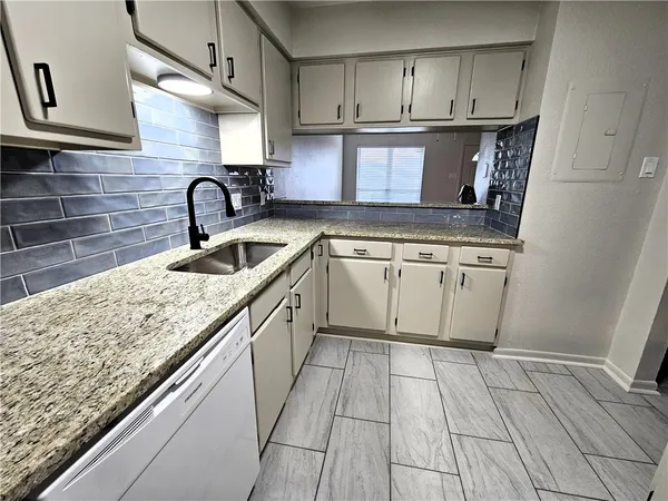 a kitchen with stainless steel appliances granite countertop a sink stove and cabinets