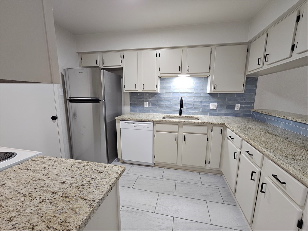 4816 Delwood Street, Unit 4 Corpus Christi, TX 78413 - Photo 7 of 22 a kitchen with a sink a refrigerator and a stove
