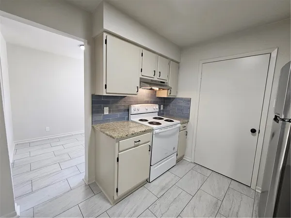 a kitchen with a stove top oven and cabinets