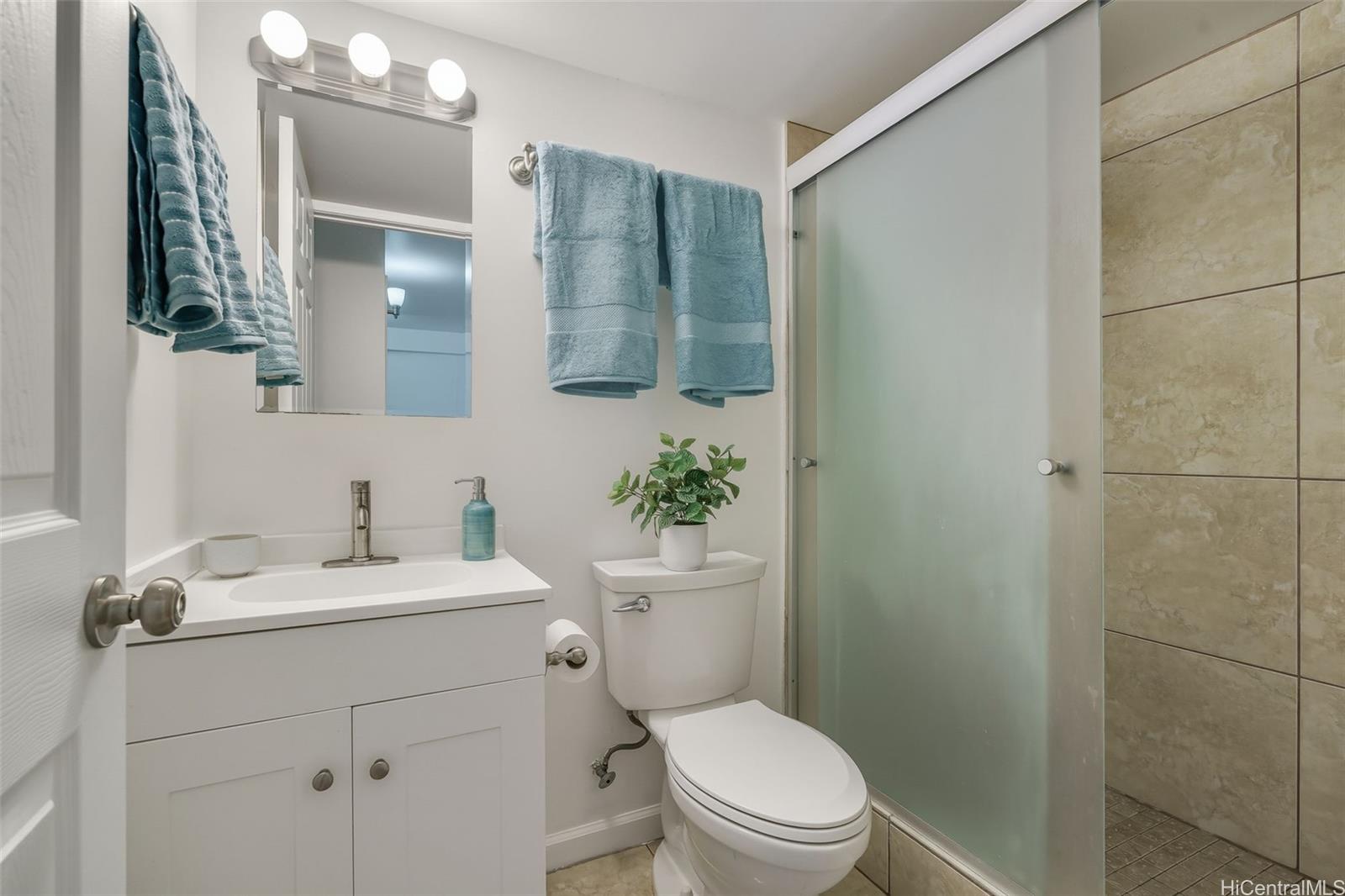 910 Ahana Street, Unit 308 Honolulu, HI 96814 - Photo 12 of 20 a bathroom with a toilet a sink a mirror a vanity and shower