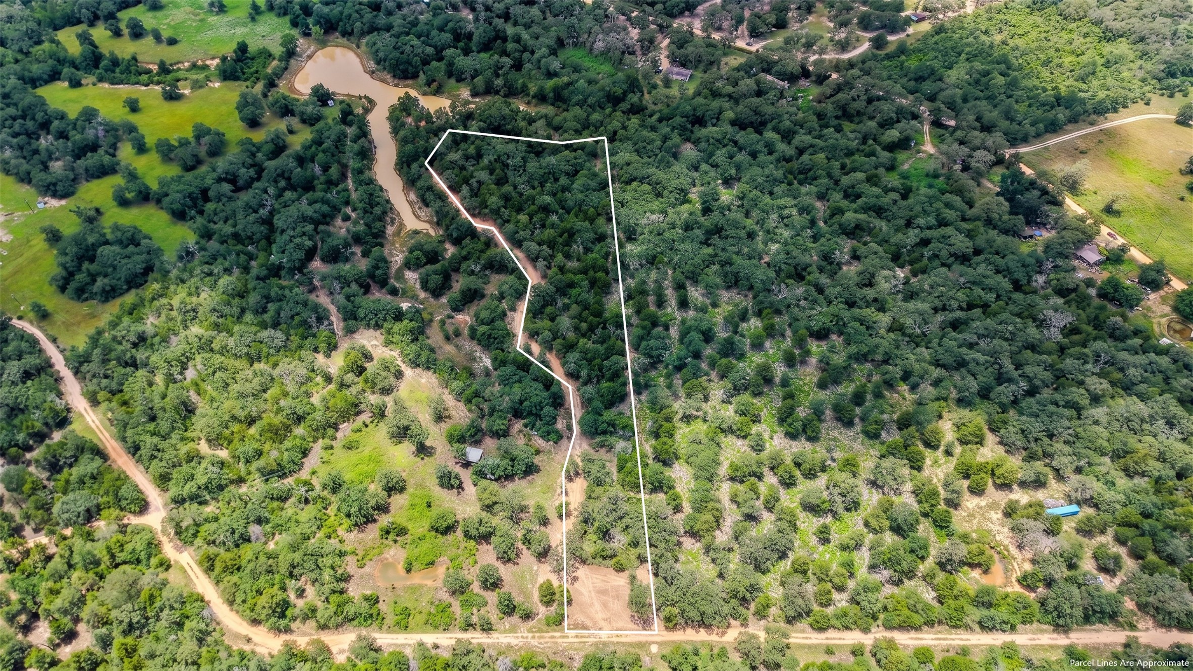 3428 (2.528 Acres In Lin Luce Ranches Milano, TX 76556 - Photo 4 of 23 A verdant, sprawling acreage featuring mature trees and a tranquil pond, outlined by a clear property boundary.