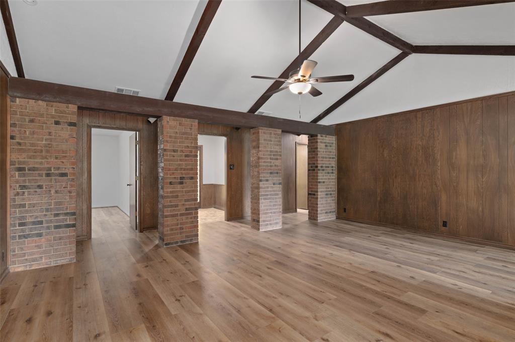 301 East 6th Street Krum, TX 76249 - Photo 13 of 29 Living room with vaulted ceiling, ceiling fan and new wood-type flooring.