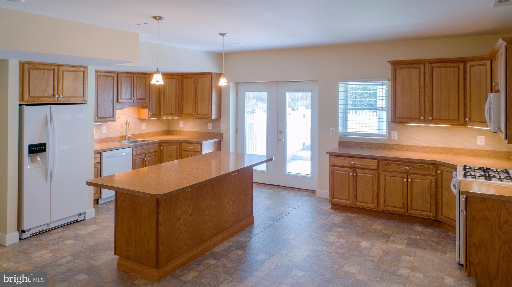 824 Andover Road Linthicum, MD 21090 - Photo 22 of 29 a kitchen with stainless steel appliances granite countertop a refrigerator a sink dishwasher a oven and a large countertops with wooden floor