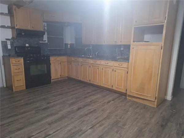 a kitchen with wooden floors and cabinets