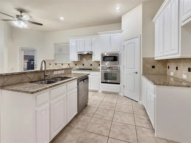 a kitchen with stainless steel appliances a refrigerator sink and cabinets