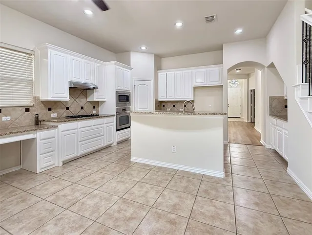 a view of an empty room with a fireplace and a window