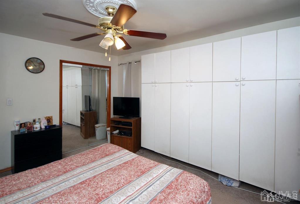 28 Magnolia Road Iselin, NJ 08830 - Photo 10 of 37 a bedroom with a bed and a chandelier