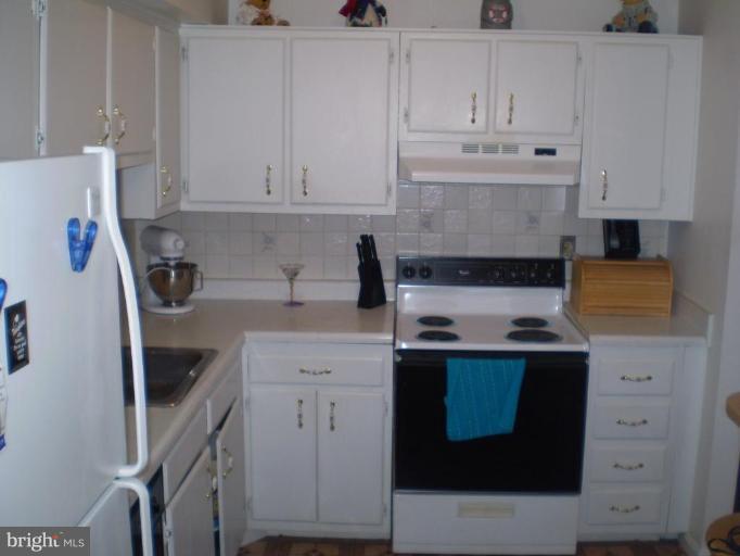 5447 Princess Drive Rosedale, MD 21237 - Photo 7 of 16 a kitchen with stainless steel appliances granite countertop a stove a refrigerator a sink and white cabinets