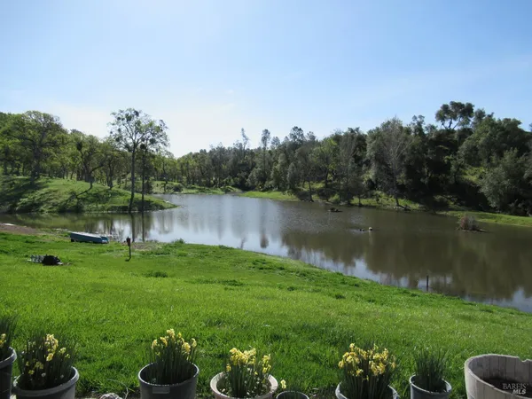 a backyard of a house with lots of green space and lake view