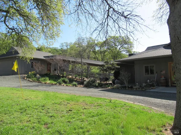 a view of a chair and table in backyard of the house