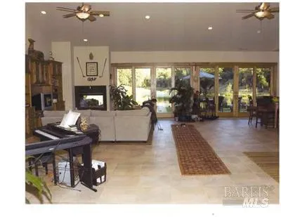 a living room with furniture a floor to ceiling window and a table